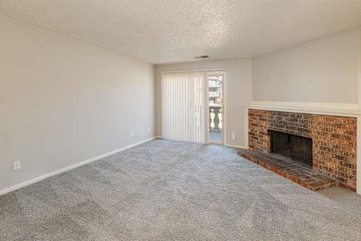 A room with a fireplace and a sliding glass door.