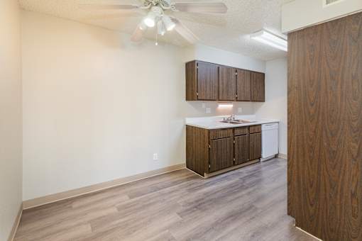 A kitchen with wooden cabinets and a ceiling fan.