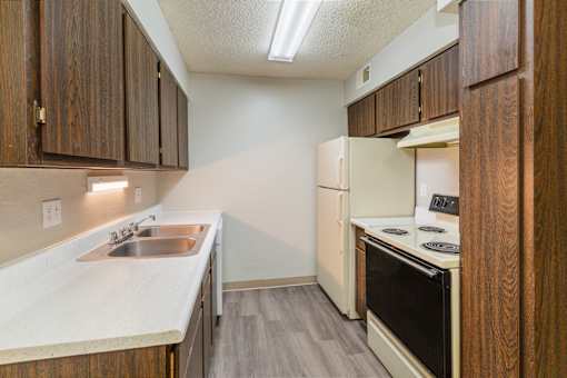 A kitchen with a sink, stove, and oven.