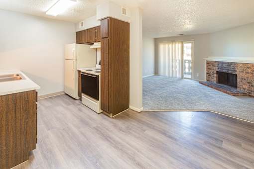 A kitchen with a refrigerator, oven, and cabinets.