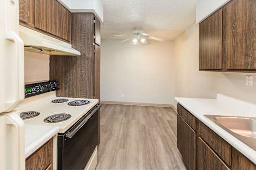 A kitchen with a white stove top oven and a white counter top.