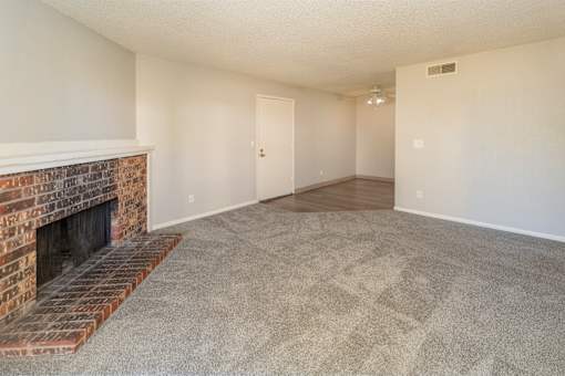 A room with a fireplace and carpeted floor.
