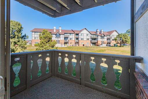 A balcony with a railing that has hourglass designs on it.