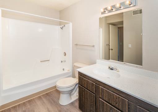 A white toilet sits in a bathroom next to a sink.