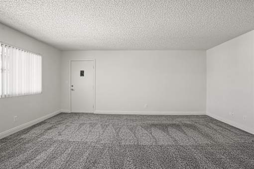 A room with a carpeted floor and a door.