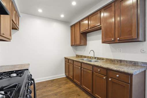 A kitchen with wooden cabinets and a granite countertop.