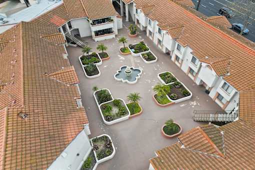A courtyard surrounded by buildings with a fountain in the middle.