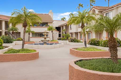 A large house with a courtyard and palm trees.