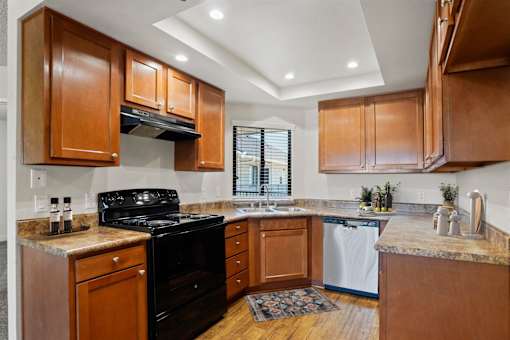 A kitchen with wooden cabinets and a black stove top oven.