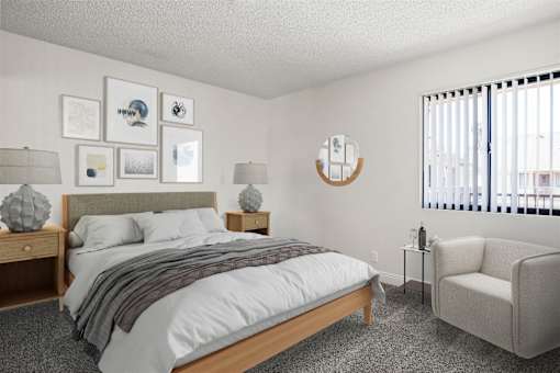 A bedroom with a bed, chair, and pictures on the wall.
