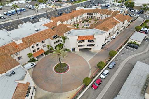 A courtyard surrounded by buildings with a palm tree in the middle.