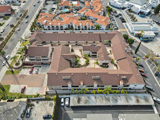 An aerial view of a residential area with houses and parked cars.