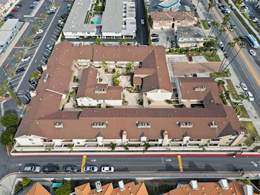 An aerial view of a large building with a parking lot in front.
