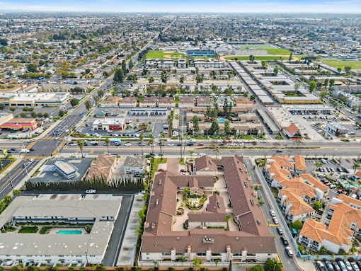 A bird's eye view of a city with buildings, roads, and vehicles.