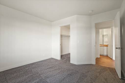 A spacious room with a carpeted floor and white walls.
