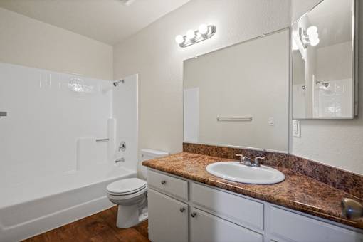 A bathroom with a sink, toilet, and bathtub.