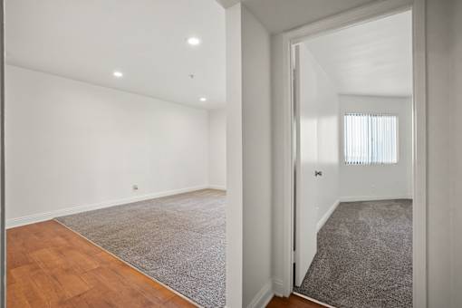 A room with a grey carpet and wooden floor.
