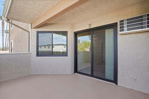 A patio area with a sliding glass door and a window.