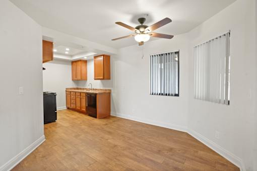 A room with a ceiling fan and wooden flooring.
