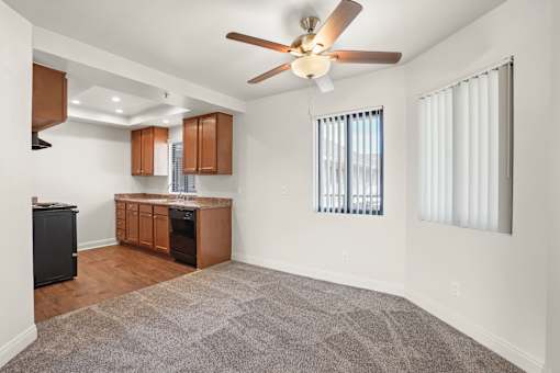 A kitchen with a fan and a window with blinds.