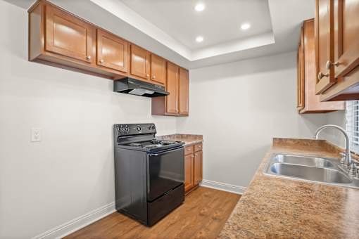A modern kitchen with wooden cabinets and a black dishwasher.