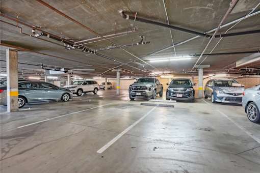 A parking garage with multiple cars parked.