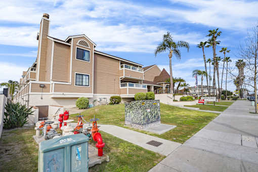 A residential building with a red fire hydrant in front of it.