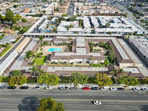 A large building with a pool in the middle of a grassy area.