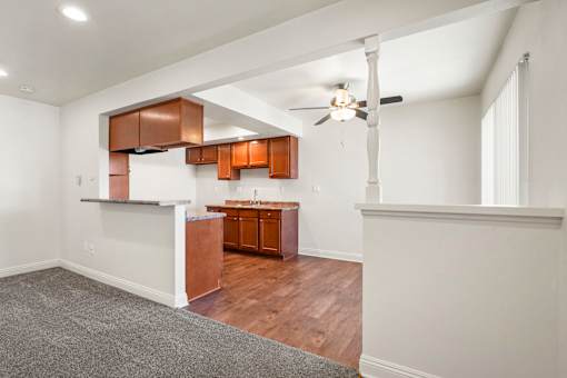 A room with a ceiling fan and wooden floors.