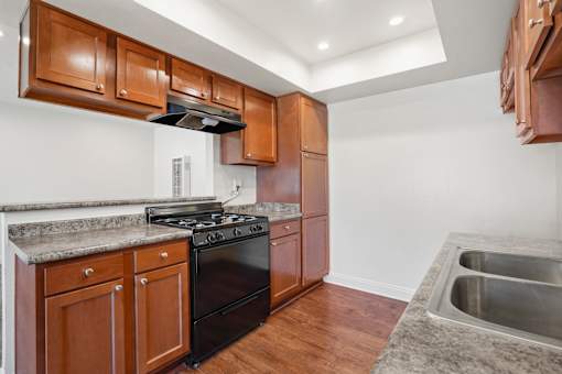 A kitchen with wooden cabinets and a black stove top oven.
