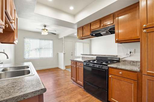 A kitchen with wooden cabinets and a black stove top oven.