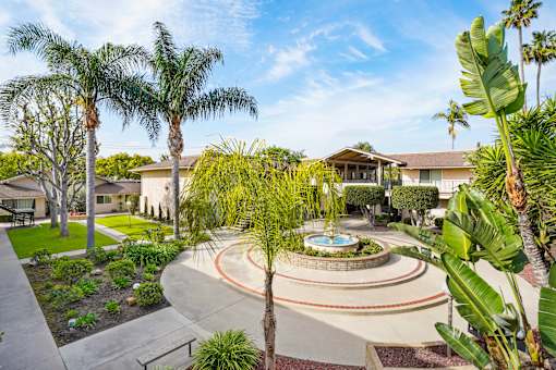 A beautifully landscaped garden with a fountain at its center.