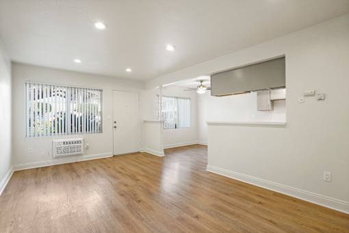 A spacious room with wooden floors and white walls.