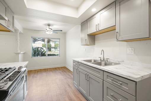 A kitchen with a stove top oven and a marble counter top.