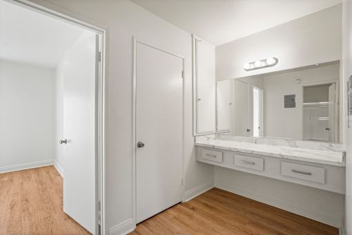 A white bathroom with a vanity and medicine cabinet.
