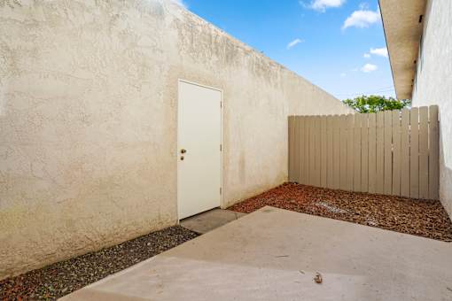 A white door is closed in a concrete room.