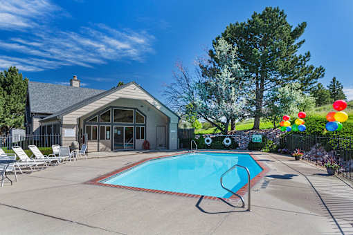 A pool with a slide and a house in the background.