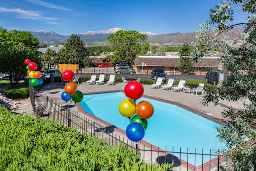 A pool surrounded by trees and balloons.