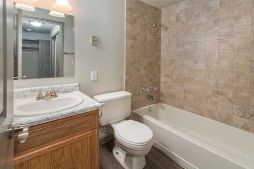 A bathroom with a toilet, sink, and bathtub.