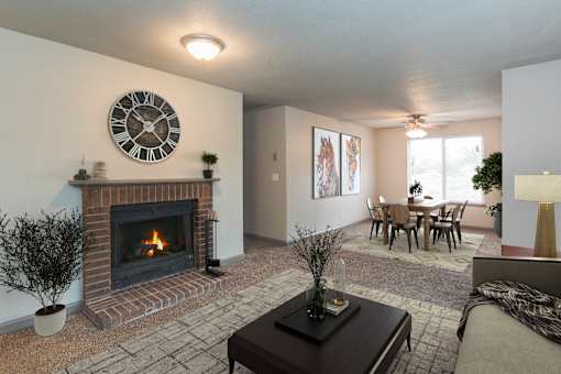A living room with a fireplace and a clock on the wall.