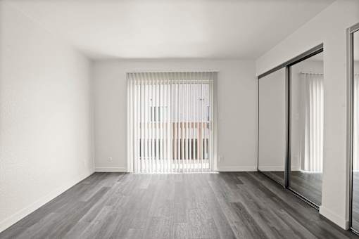 A room with a sliding glass door leading to a balcony.