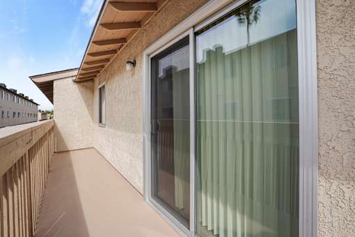 A balcony with a glass door and a window.