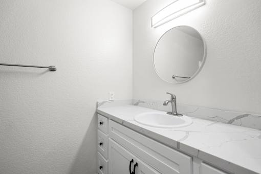 A bathroom with a sink and a mirror.