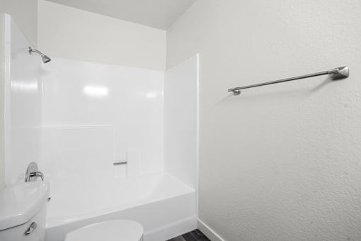 A white bathroom with a toilet, sink, and bathtub.