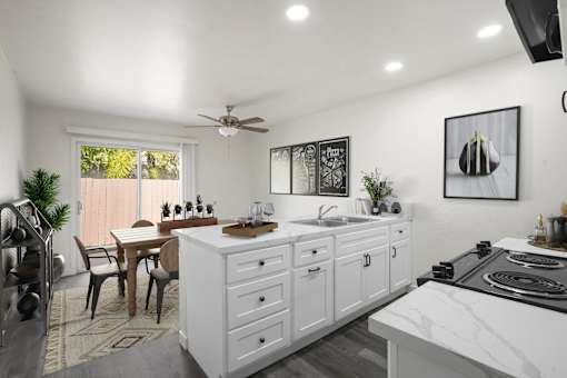 A modern kitchen with white cabinets and a marble countertop.