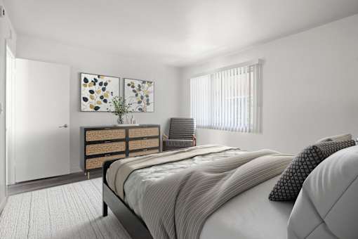 A bedroom with a bed, nightstand, and two paintings on the wall.