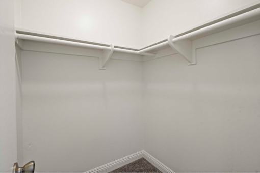 A white room with a corner and a carpeted floor.