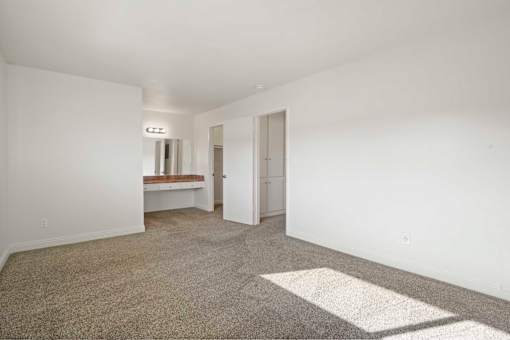 A room with a carpeted floor and a white door.