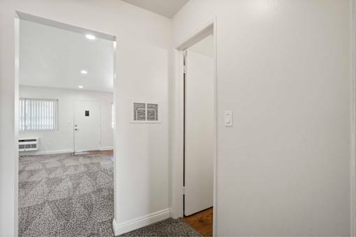 A white hallway with a door on the right.