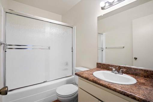 A bathroom with a toilet, sink, and shower.